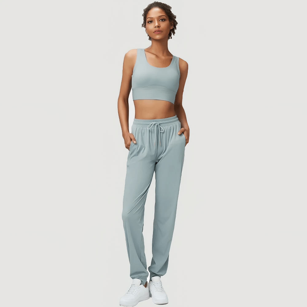 Women's stylish joggers and sports bra set in serene blue, featuring adjustable drawstrings and breathable fabric. Perfect for active and casual wear.